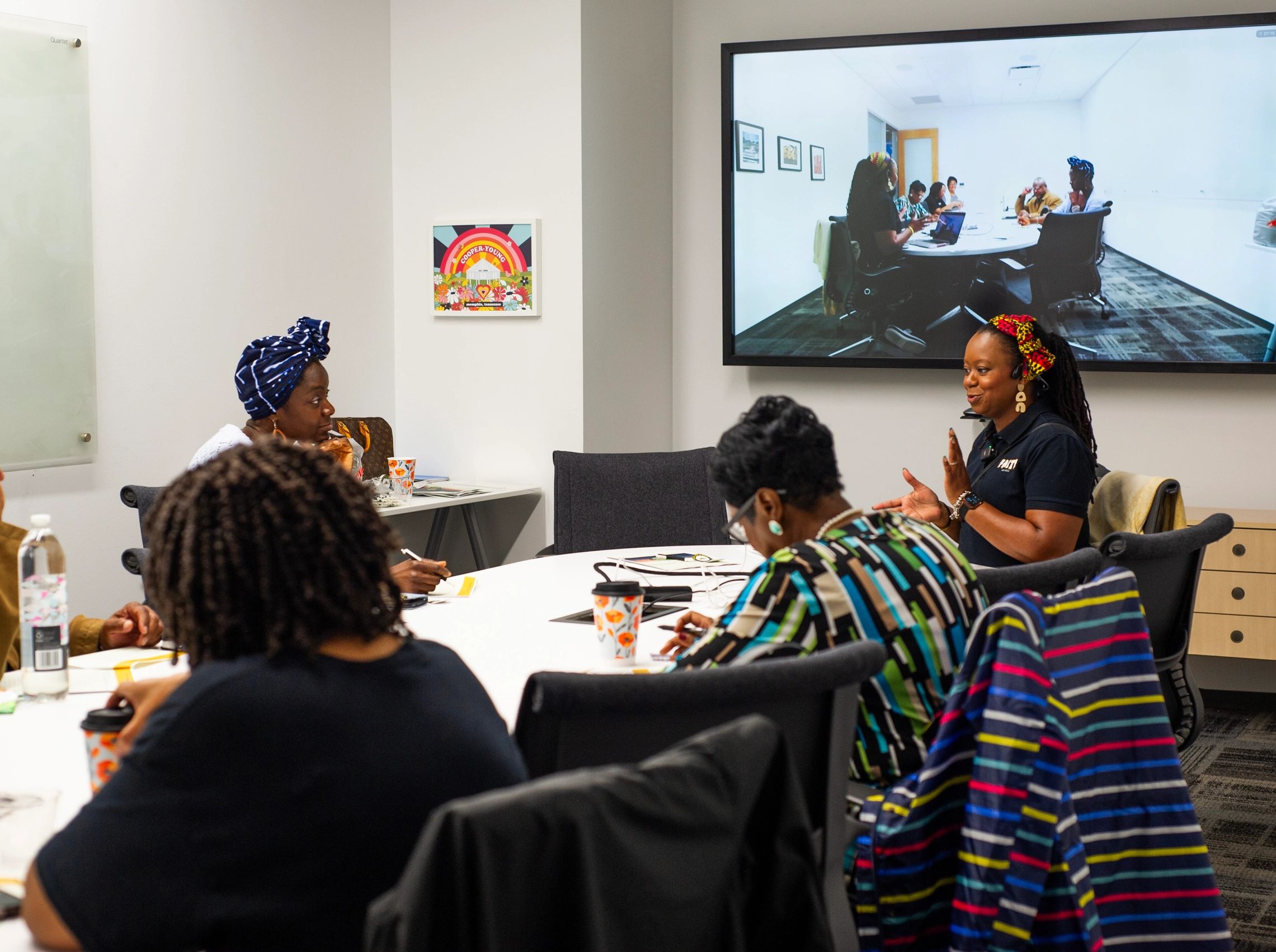 People in a meeting room with a video conference screen.