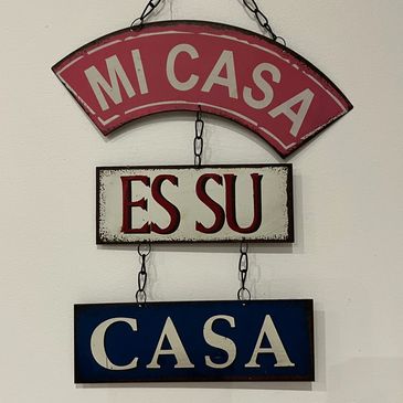 Decorative hanging sign with Spanish phrase about home.