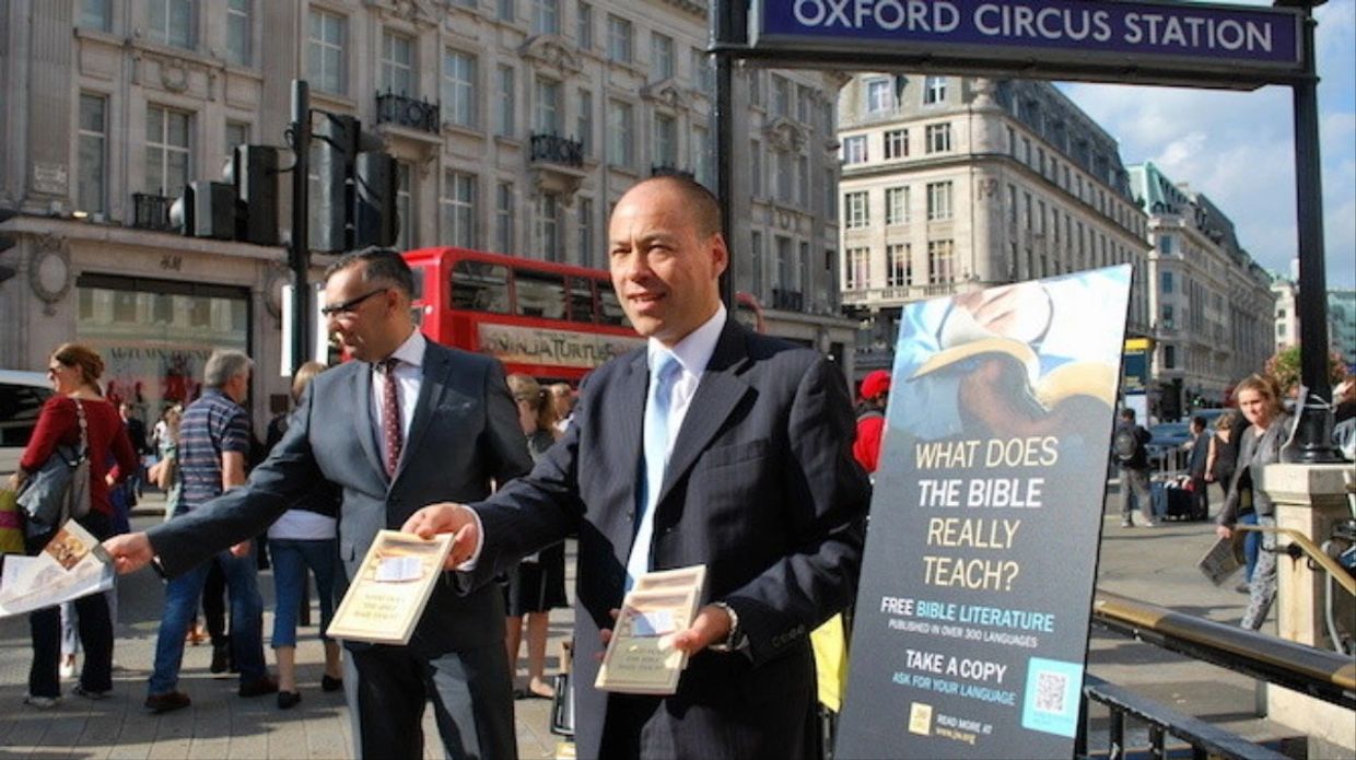Men distributing Bible literature at Oxford Circus Station.