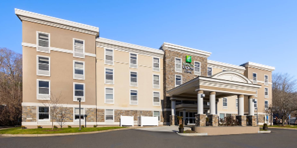 Exterior view of a modern Holiday Inn hotel under clear blue sky.