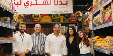 Group of five people smiling in a grocery store aisle.