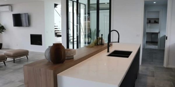 Modern kitchen with sleek island and black faucet.