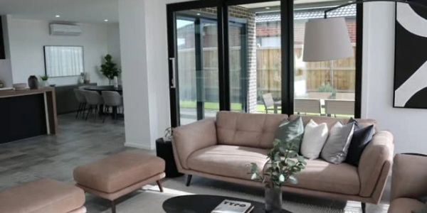 Modern living room with beige sofa, glass doors, and minimalist decor.