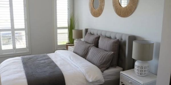 Cozy modern bedroom with gray bedding and natural decor.