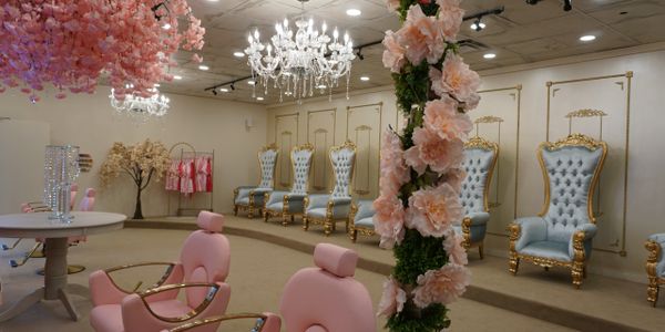 Elegant room with pink chairs, floral decor, and ornate blue and gold chairs.