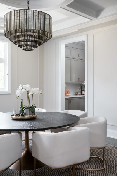 Modern dining room with round table and chandelier.