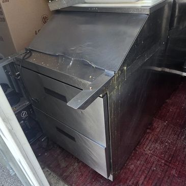 Old stainless steel kitchen appliance with two drawers.