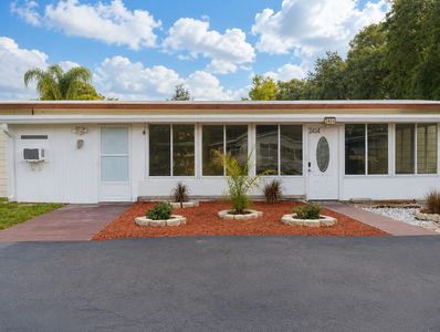 Single-story house with large windows and a front garden.