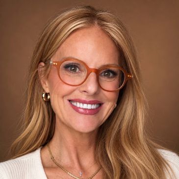 Smiling woman with glasses and blonde hair.