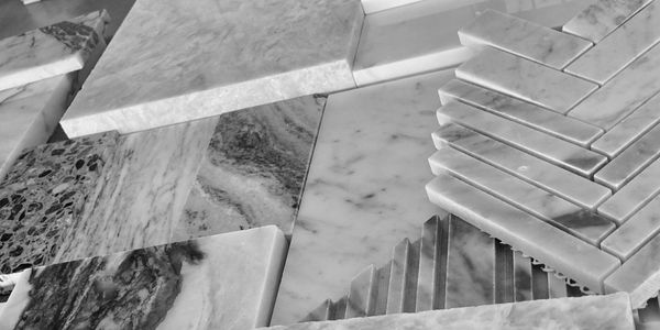 Varied marble tiles with different shapes and textures arranged closely together.