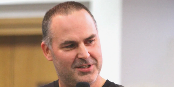 Man speaking into a microphone during an event.