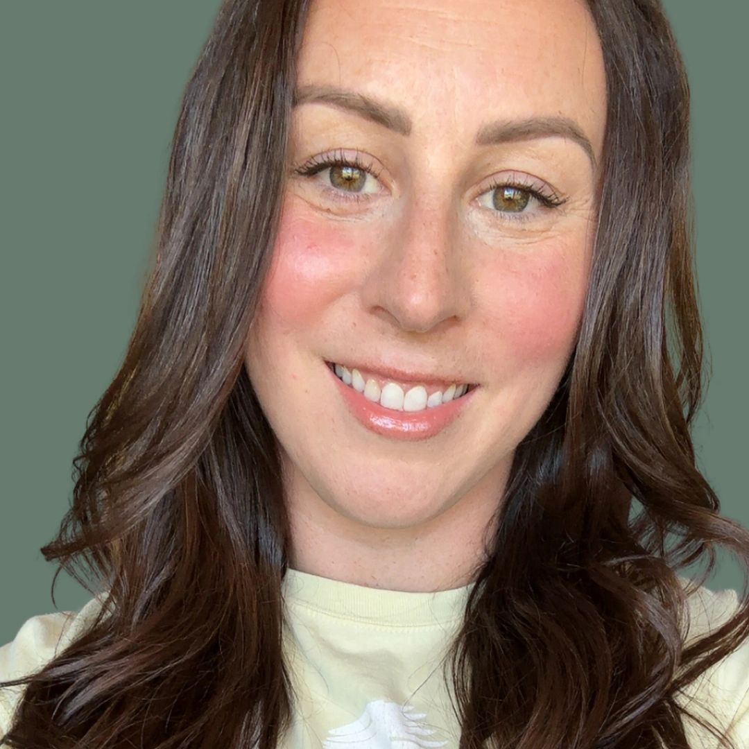 Smiling woman with long dark hair and a light-colored shirt.