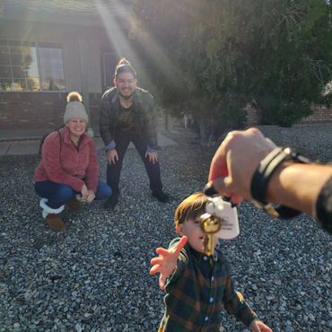 Family celebrates new home with child reaching for keys.