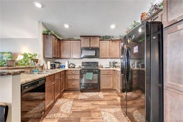 Modern kitchen with wooden cabinets and black appliances.