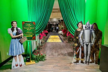 Entrance decorated with Wizard of Oz characters and green drapes.