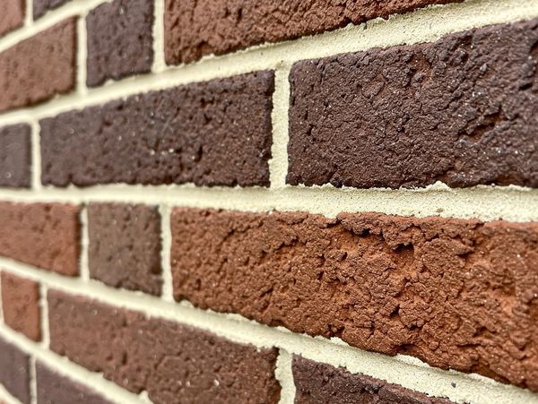 Tuckpointing a brick wall in Toronto, showcasing masonry work by Chapa Company.