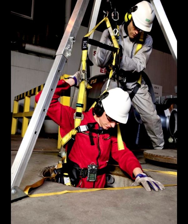 rescue team member hoisting worker out of manhole