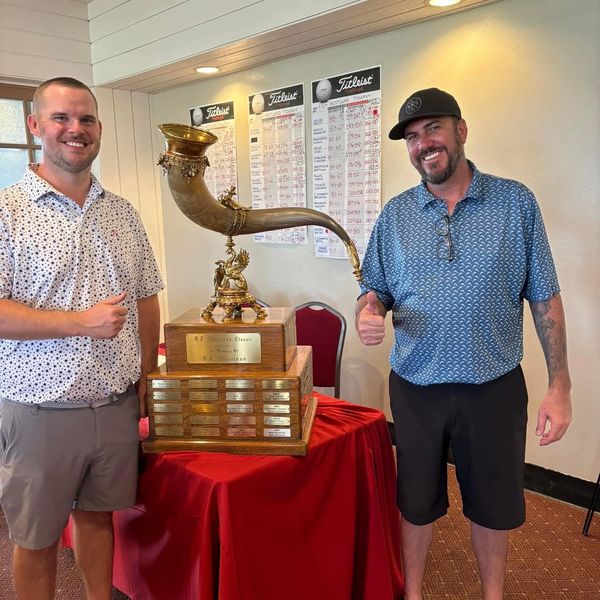 person standing in front of a trophy.