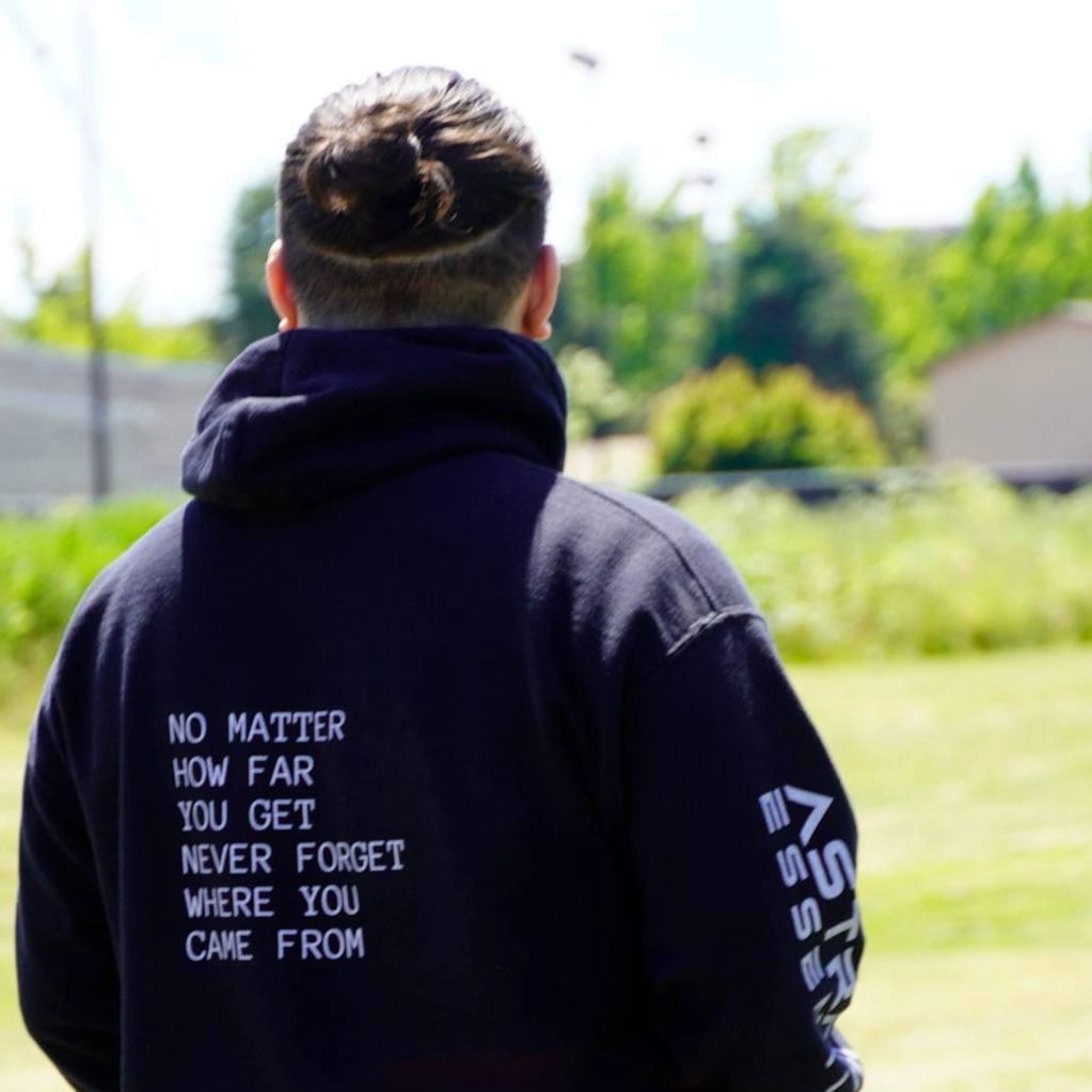 Model wearing "Motto" Hooded Sweatshirt looking into the distance
