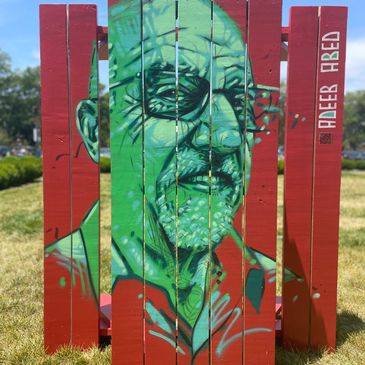 Colorful graffiti portrait of an older man on wooden red panels outdoors.