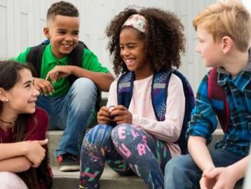 Group of happy children sitting and chatting.