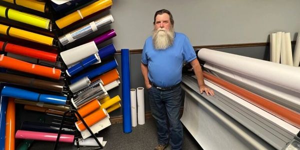 Kevin at the shop in front of his digital printer.