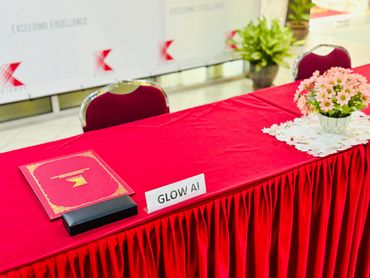 Table with red cloth and nameplate 'GLOW AI'.