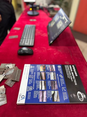 Table with computer accessories and a welding visual inspection guide.