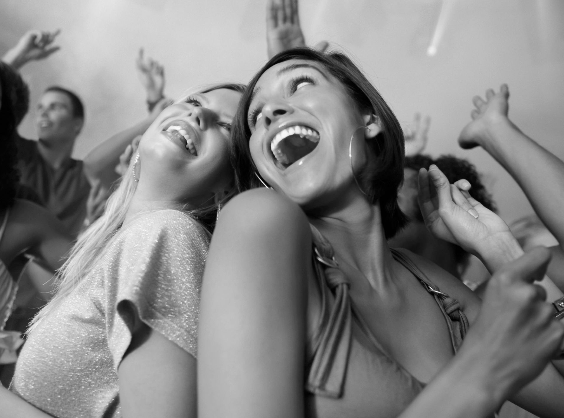 Two women joyfully dancing at a party.