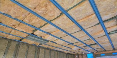 Ceiling insulation installation in progress with metal framing.
