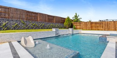 Modern backyard pool with water fountain and slide.