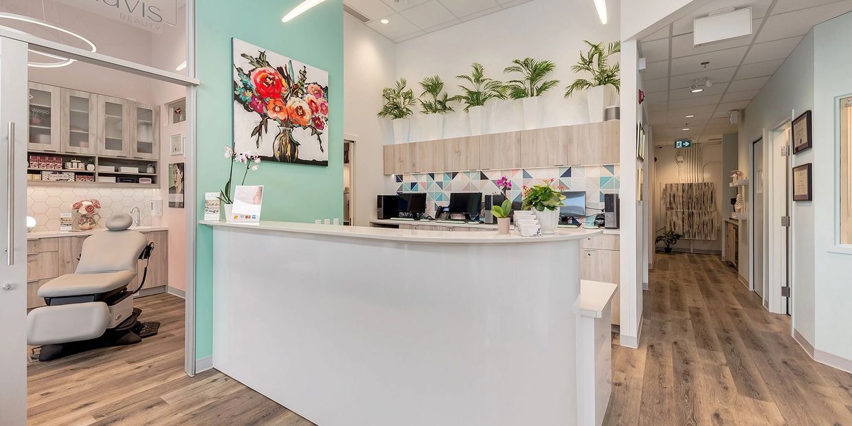 Bright and modern beauty clinic reception with plants and floral decor.