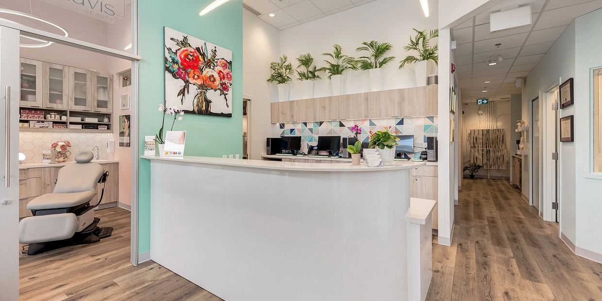 Bright and modern beauty clinic reception with plants and floral decor.