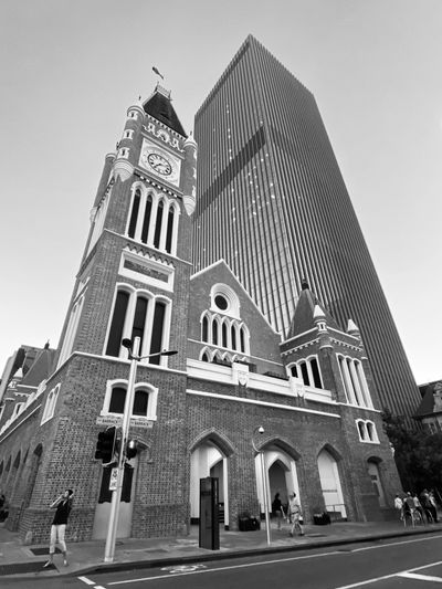 view of a tall building and people walking on a street 