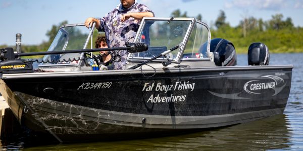 Fishing boat named Fat Boyz Fishing Adventures on water.