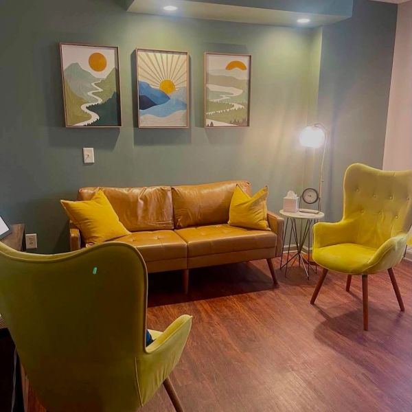 Cozy living room with mustard yellow furniture and nature-inspired wall art.