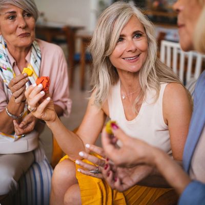 A diverse group of happy women representing the Savvy Pink Peppers social club for women over 50. Bu