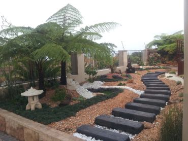 A landscaped garden with a stone path and greenery.