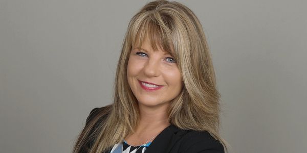 Professional woman smiling confidently in a studio portrait.