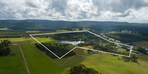 Aerial view of a large rural property outlined in white with fields, trees, and a small lake.