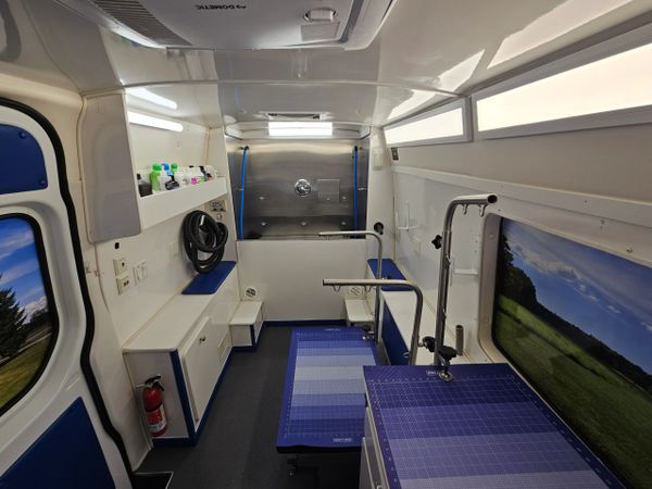 Clean, organized grooming station inside a mobile pet grooming van.
