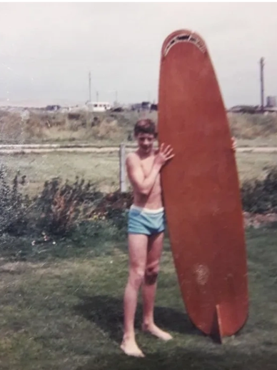 Me in the early sixties with the wooden surfboard I made