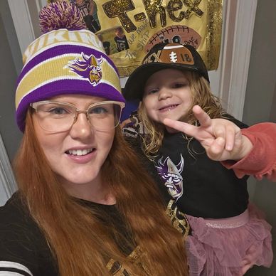 Woman and child wearing Minnesota Vikings apparel, smiling and posing.