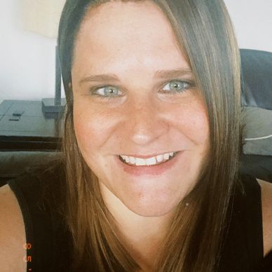 Smiling woman with straight brown hair and blue eyes.