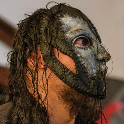 Person wearing a detailed stitched metal mask.