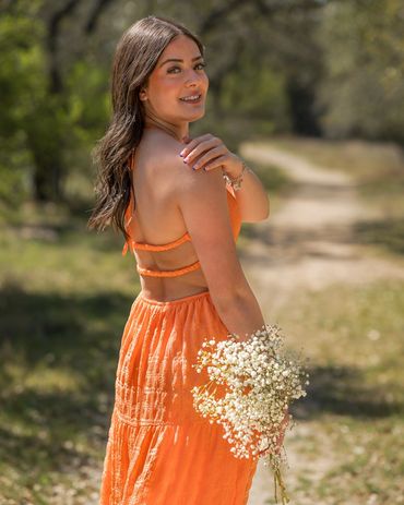 Girl in orange dress, holding flowers
