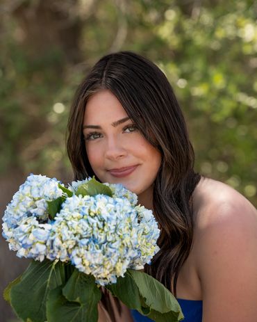 Girl leaning holding hydrangeas near face