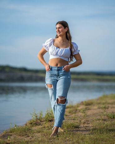 Girl walking by lake with hands in pocket