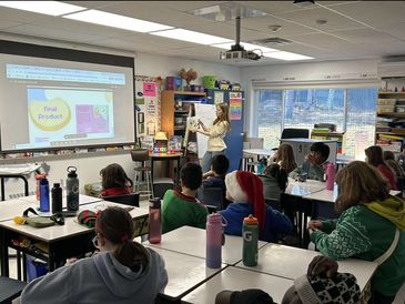 Teacher presenting a lesson to attentive students in a classroom.