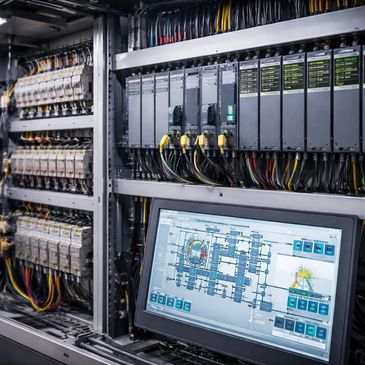 Industrial control panel with wiring and a touchscreen interface.